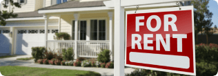 yellow duplex with a for rent sign in yard